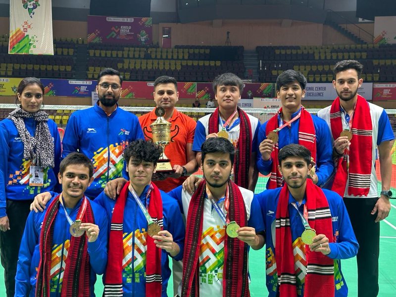 The gold-medal badminton team with medals, trophy and shawls at the Khelo India University Games